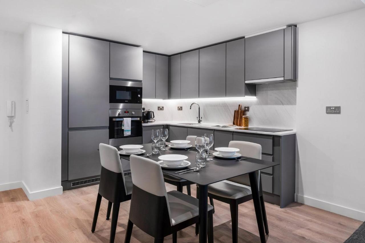Citysuites 2 Aparthotel Mánchester Exterior foto The photo shows a modern kitchen and dining area. The kitchen features sleek, gray cabinetry and a countertop that complements the overall aesthetic. There are built-in appliances, including an oven and refrigerator, arranged neatly. Next to the kitc